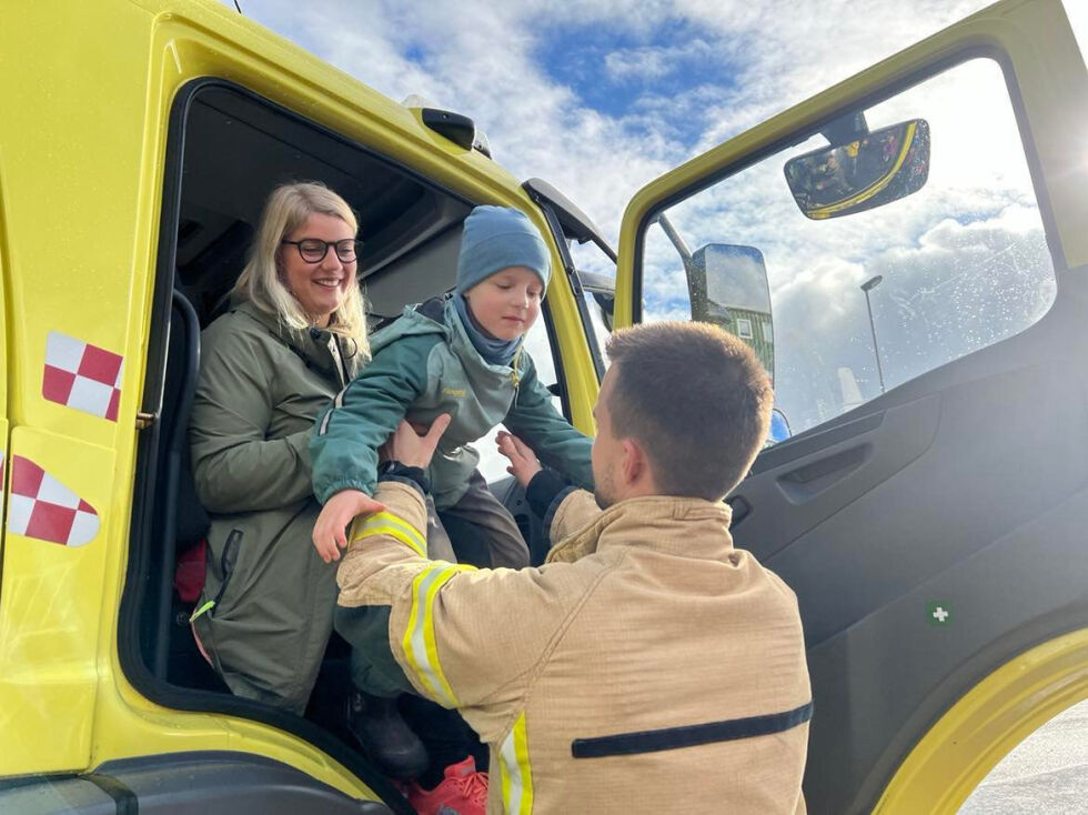 Friedrike og Noel Johan Sørensen fikk hjelp ut av brannbilen etter en fin tur med sirener og blålys.
 Foto: Lillian Lyngstad