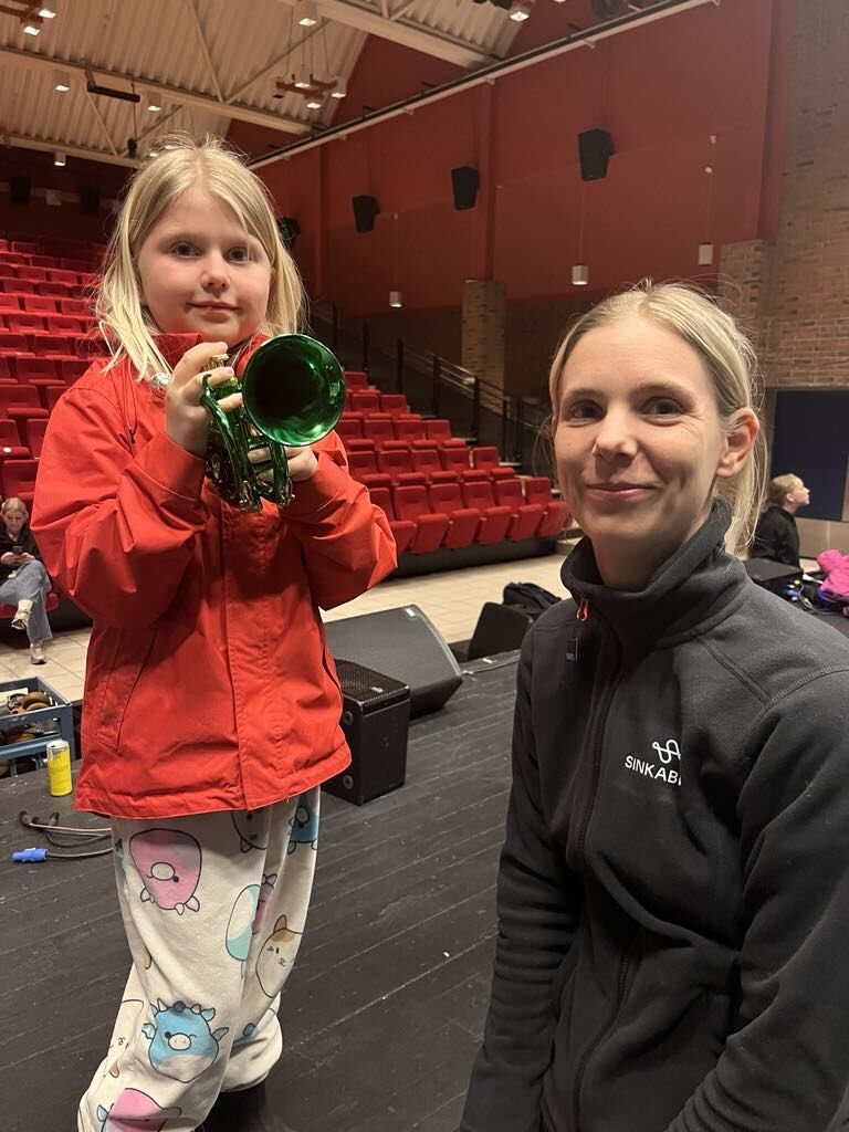 Dirigent Eirin Ottesen viser Emma Øyahals hvordan hun får lyd i pocket-trompeten.
 Foto: Eirin Kristiansen Ramstad