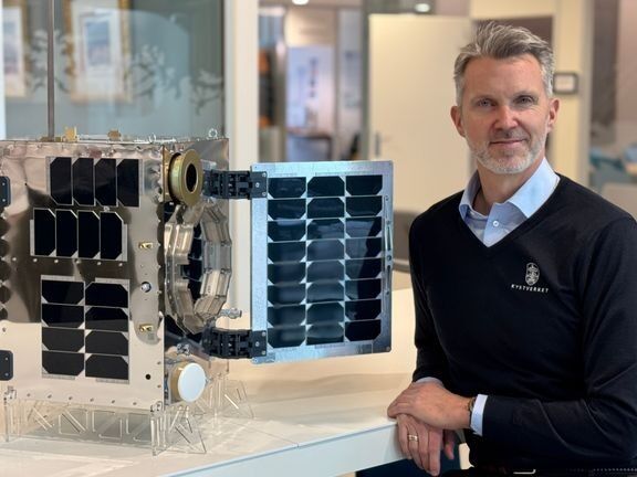 En modell av Norsat-4 i faktisk størrelse sammen med kystdirektør Einar Vik Arset.
 Foto: Gro Kibsgaard/Kystverket