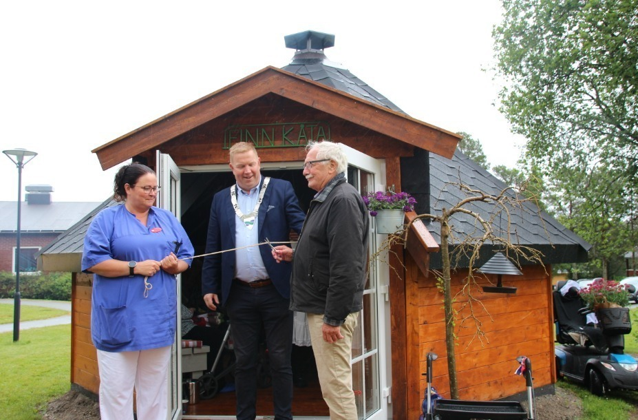 Hege Bakken, ordføreren og Finn Øseth står klare til å åpne den nye grillhytta i bakgården på Nærøy bo - og behandlingssenter.