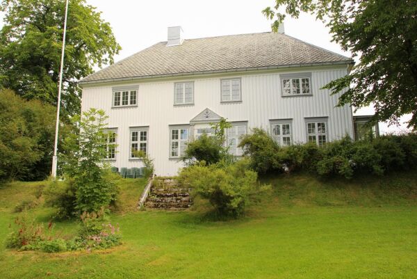 Inviterer til hagefest i prestegårdshagen